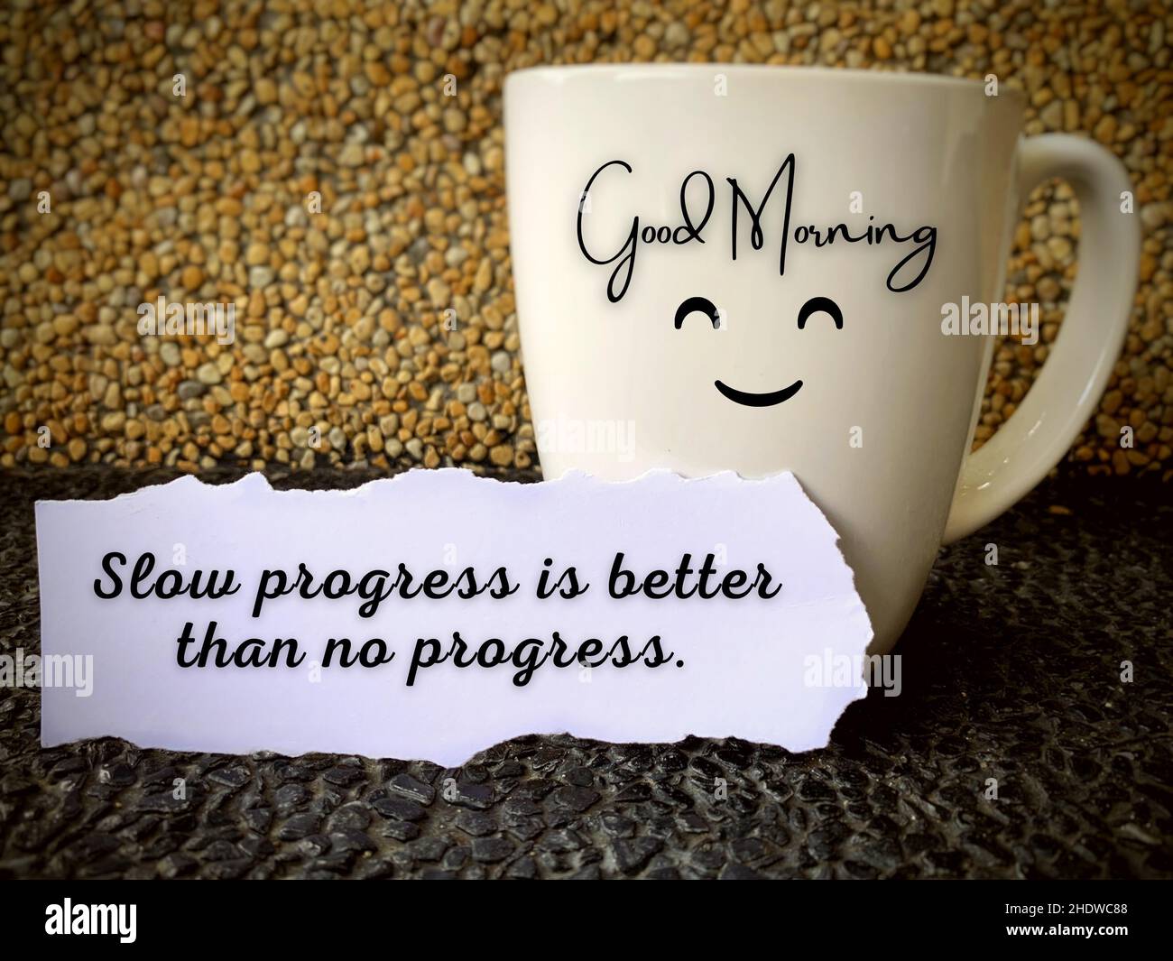 Buon testo del mattino su una tazza di caffè con citazione motivazionale su un pezzo di carta - progresso lento è meglio di nessun progresso. Concetto di mattina Foto Stock