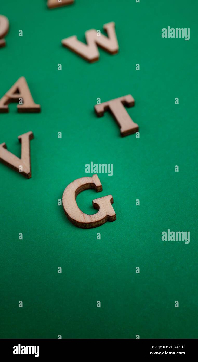 lettere di legno casuali isolate su sfondo verde Foto Stock