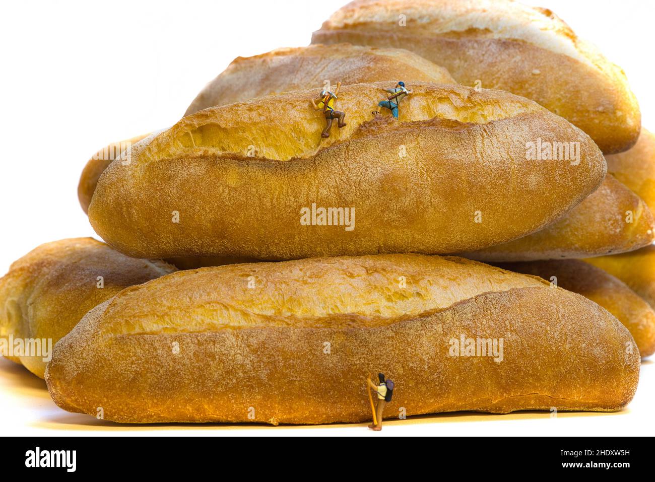 Una squadra di arrampicata in miniatura salta pane italiano fresco e croccante Foto Stock
