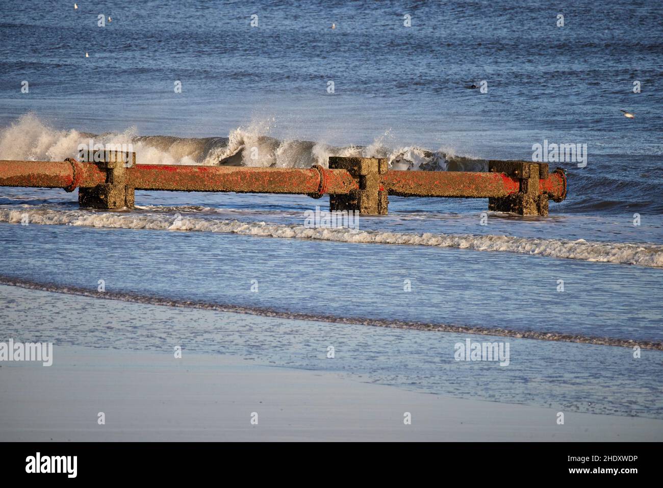 Blyth cannotto di drenaggio. Questo tubo drena l'acqua piovana in eccesso dalle strade e dai campi vicini al mare. Foto Stock