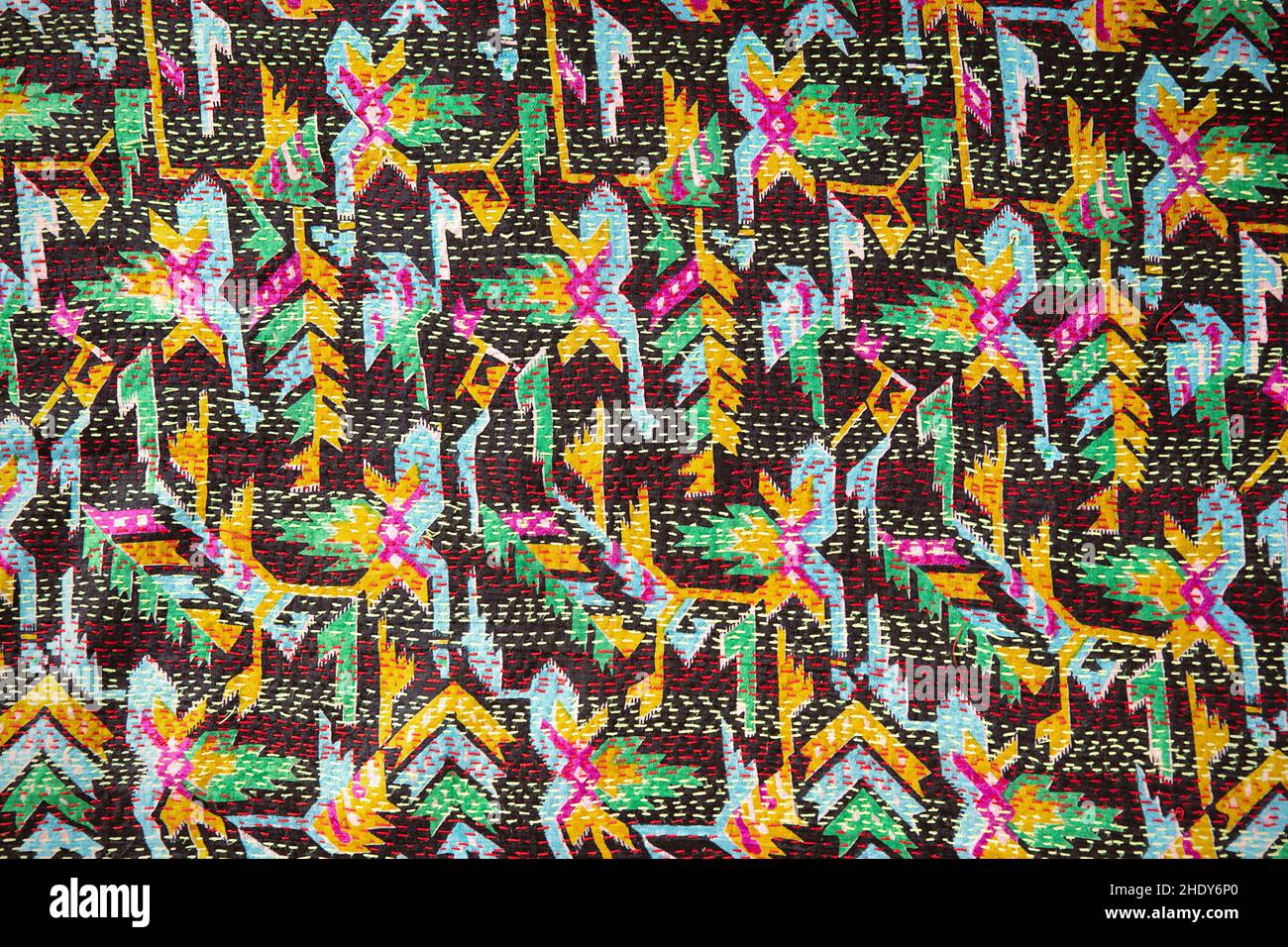 Primo piano del tessuto di seta riciclato vintage con cuciture kantha. Tecnica di decorazione tessile, trapunte fai da te kantha. Cuciture fatte a mano su colorato retro Foto Stock