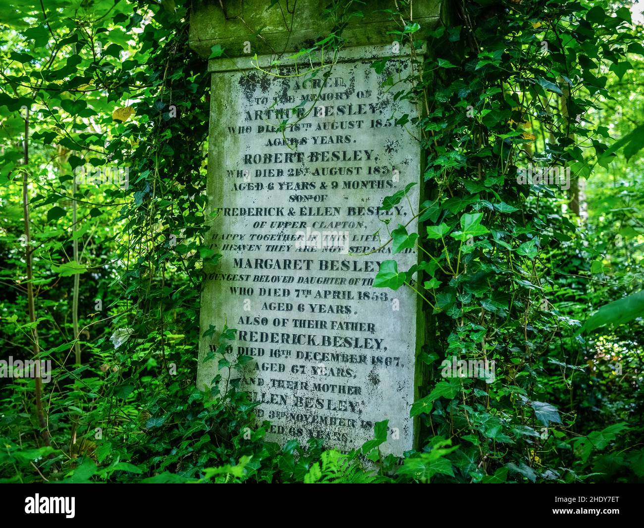 Tributo Headstone memoriale della famiglia Besley, nascosto nel verde sottobosco coperto di Ivy, preso al cimitero di Abney Park, 21st di maggio 2017 Foto Stock