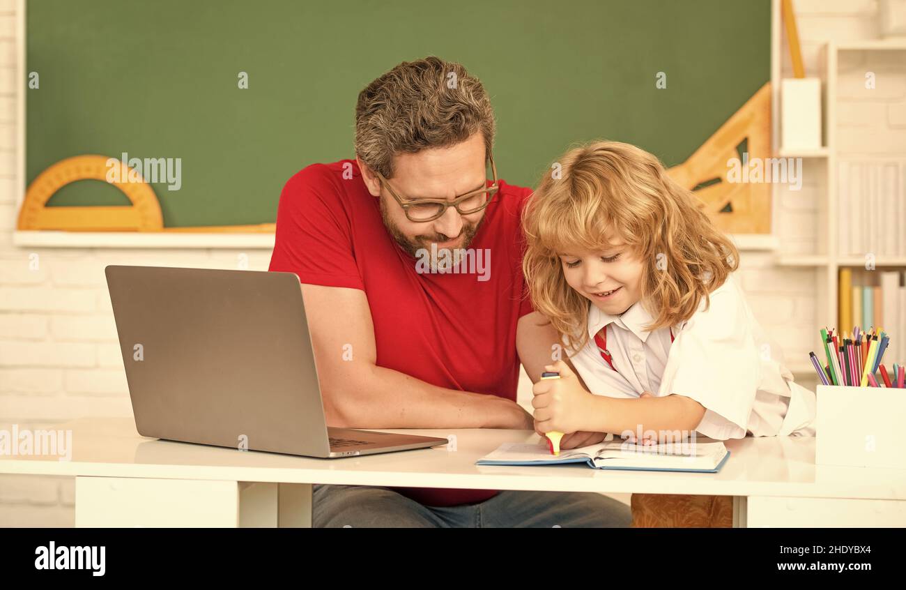 infanzia e genitorialità. ragazzo sorridente studia con insegnante privato. video lezione di webinar. Foto Stock