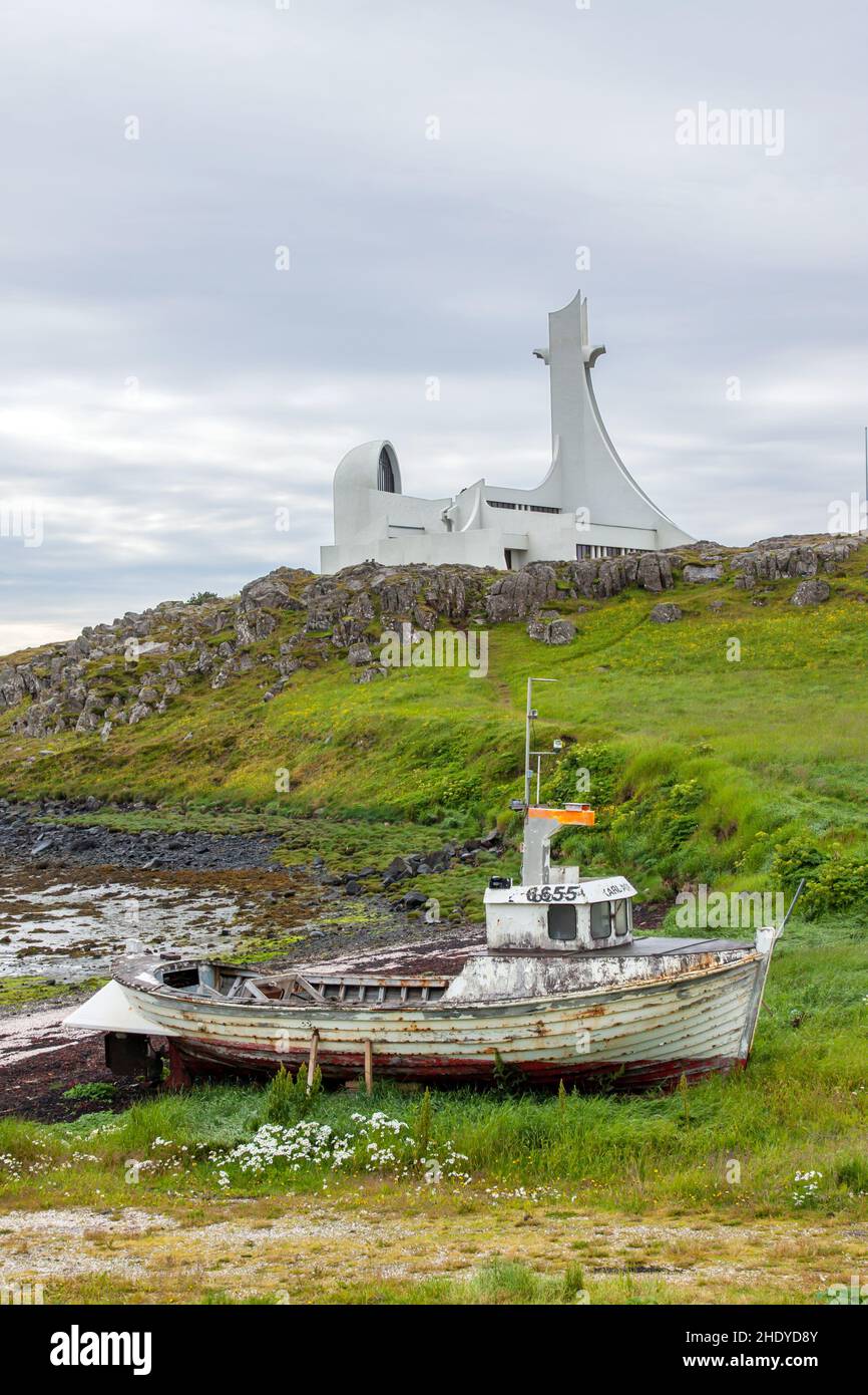 Vecchia barca e nuova chiesa con suggestive somiglianze in Islanda Foto Stock