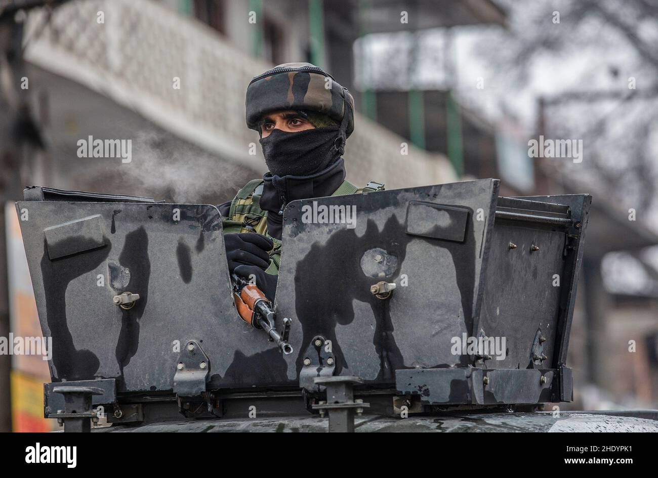 Srinagar, Kashmir controllato dall'India. 7th Jan 2022. Un troupo dell'esercito indiano si erge in cima a un veicolo blindato vicino al luogo di una lotta contro le armi al villaggio di Chadoora nel distretto di Budgam, a circa 30 km a sud della città di Srinagar, la capitale estiva del Kashmir controllato dall'India, 7 gennaio 2022. La polizia nel Kashmir controllato dall'India venerdì ha detto che tre militanti sono stati uccisi in una lotta contro le armi nella regione. Credit: Javed Dar/Xinhua/Alamy Live News Foto Stock