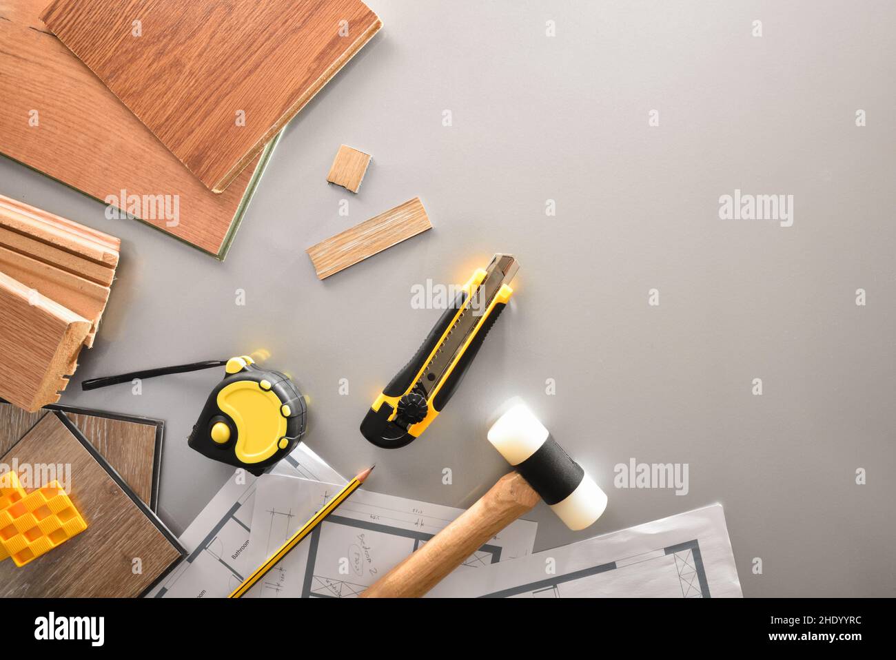 Dettaglio dei materiali e degli attrezzi sul tavolo di lavoro di un installatore di parquet con piani. Vista dall'alto. Foto Stock