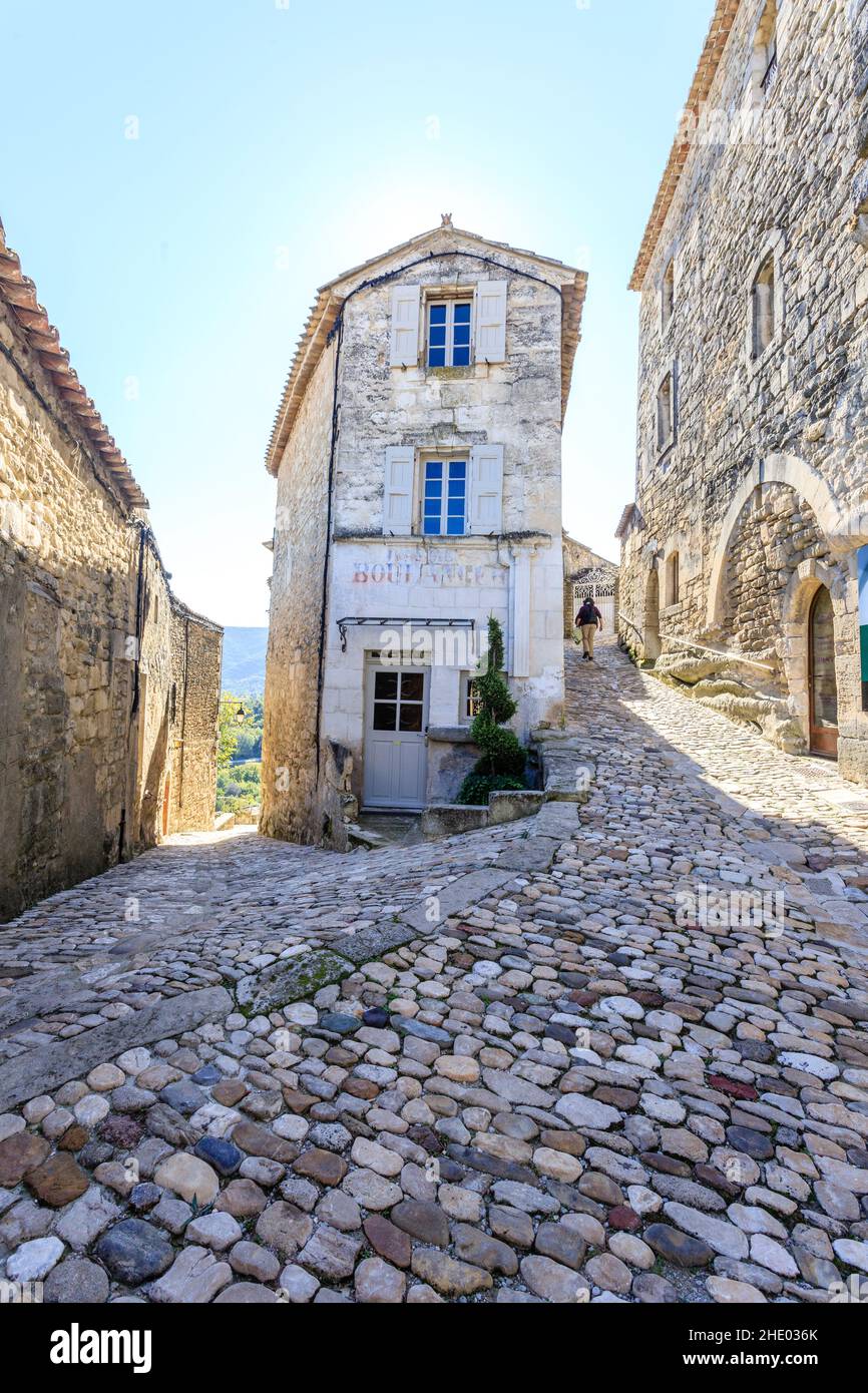 Francia, Vaucluse, Parc Naturel Regional du Luberon (Parco Naturale Regionale del Luberon), Lacoste, vicolo lastricato nel villaggio con un ciclista // Francia, va Foto Stock