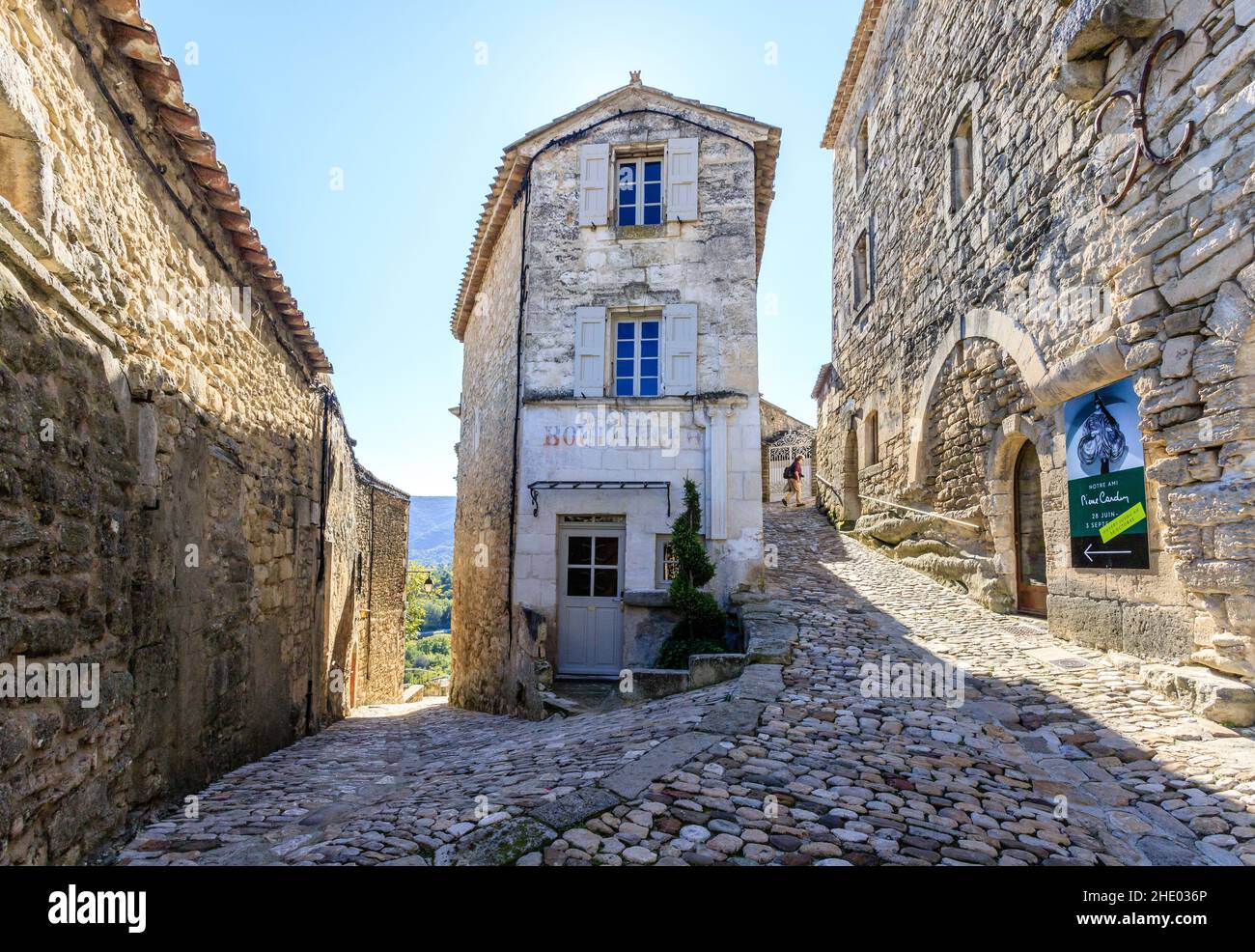 Francia, Vaucluse, Parc Naturel Regional du Luberon (Parco Naturale Regionale del Luberon), Lacoste, vicolo lastricato nel villaggio con un ciclista // Francia, va Foto Stock