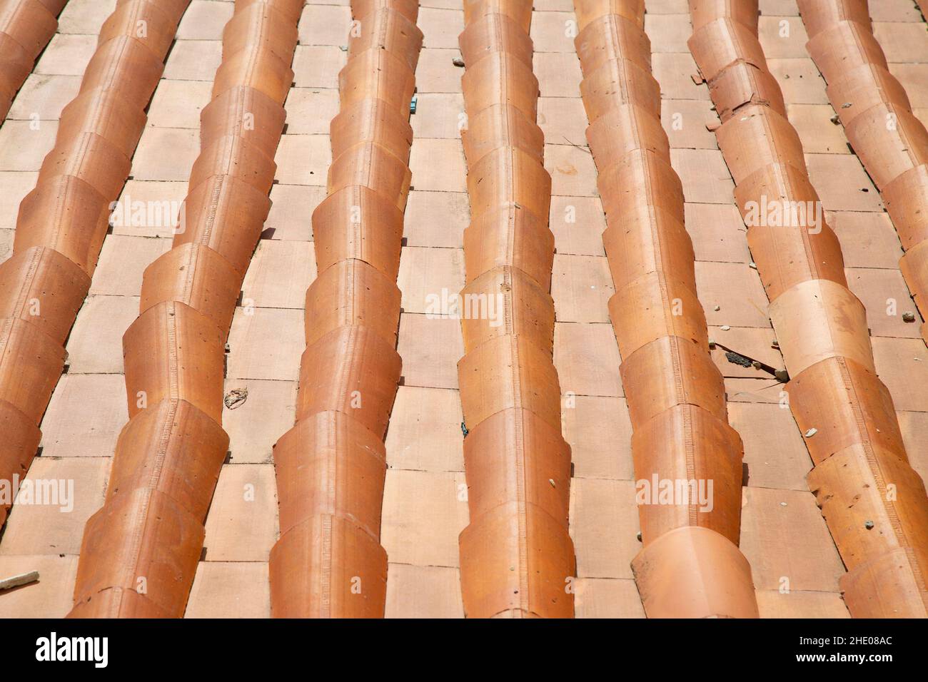 Modello del tetto con tegole arancioni. Giorno di sole. Tradizionale materiale per tetti. Sfondo e immagine di sfondo. Composizione geometrica. Costruzione storica Foto Stock