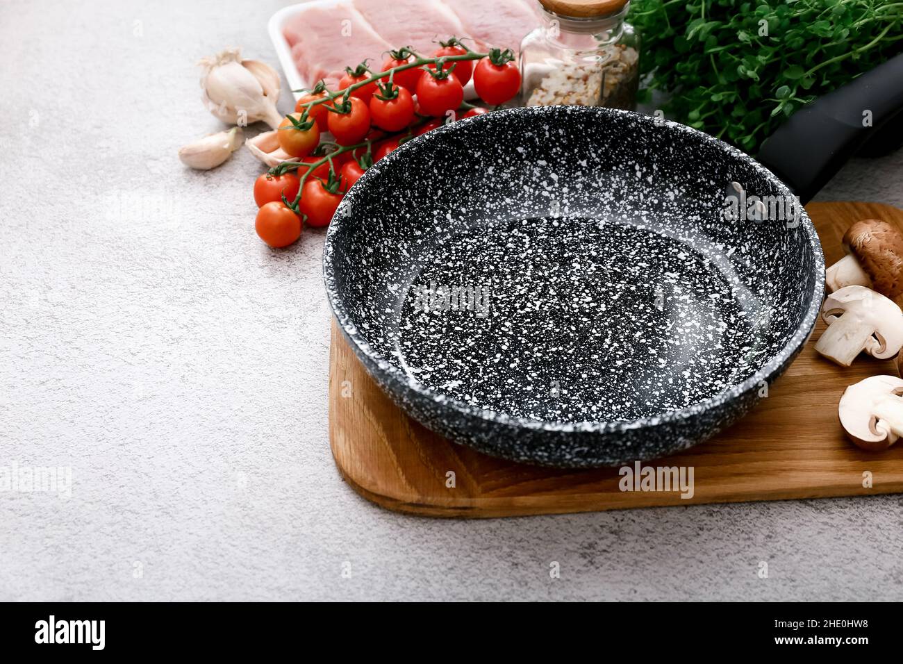 Padella in marmo nero con prodotti su sfondo grigio del tavolo, vista dall'alto Foto Stock