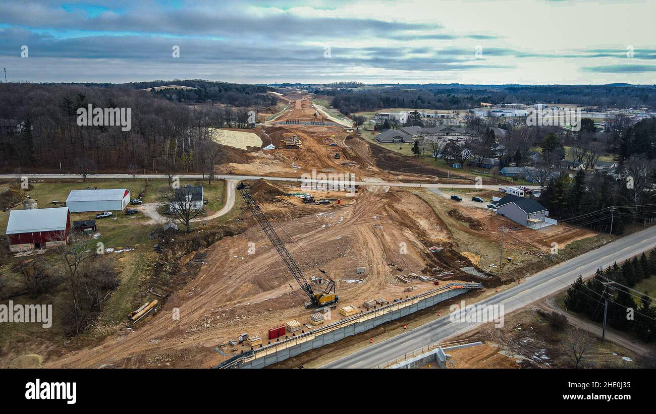 Costruzione di un nuovo sistema autostradale in piccola città con sgombero forestale e macchinari pesanti Foto Stock