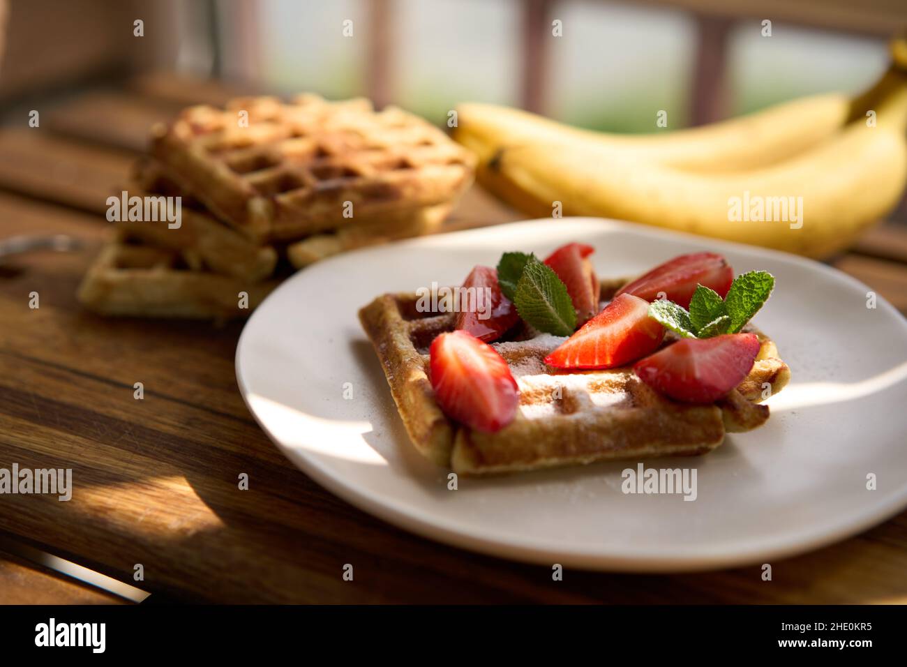 Waffle con fragole, banane e miele. Foto Stock