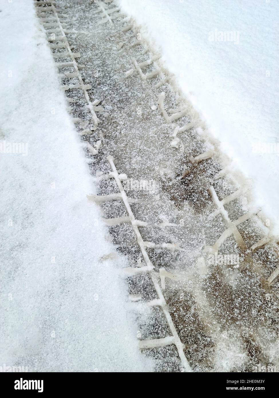 Primo piano dei cingoli degli pneumatici nella neve con sporcizia Foto Stock