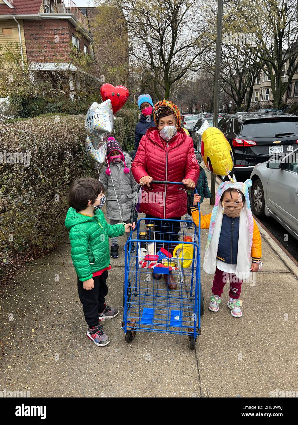 Gruppo scuola materna che cammina nel quartiere di Kensington dopo aver acquistato palloncini durante la pandemia di Covid-19 a Brooklyn, New York. Foto Stock