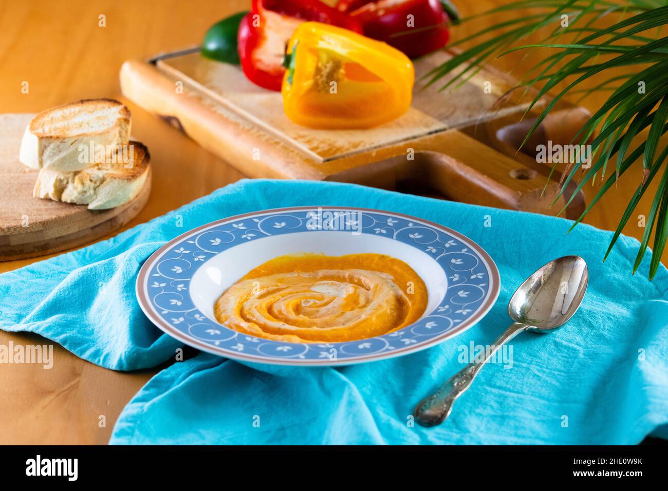 Zuppa di panna al peperone servita in un piatto blu Foto Stock