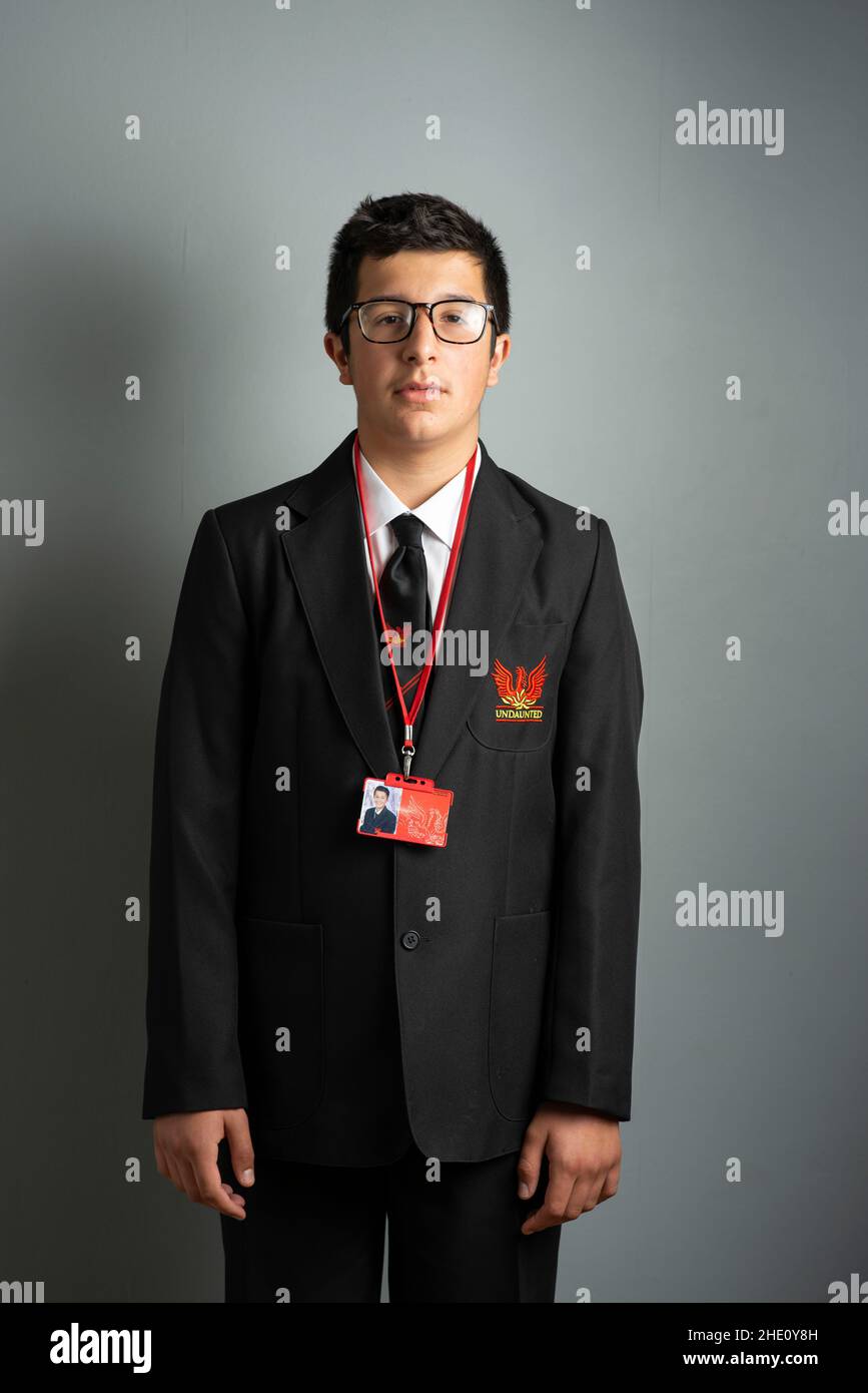 Teenager geeky , anno 9, con occhiali e divisa scolastica Foto Stock