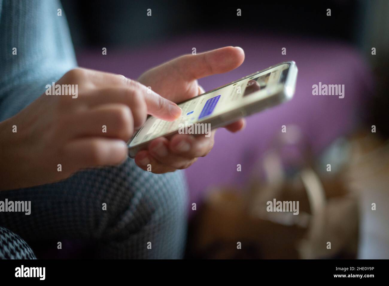 donna che parla online, invia messaggi di testo sui social media su smartphone - primo piano, focus selettivo Foto Stock