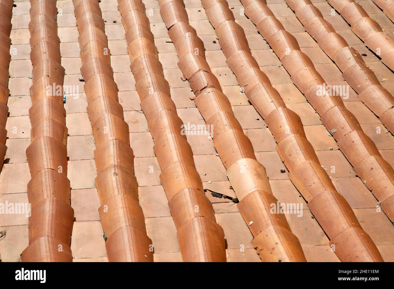 Top vie al tetto piastrellato in giornata di sole. Tradizionale materiale per tetti. Sfondo e immagine di sfondo. Composizione geometrica. Costruzione storica Foto Stock