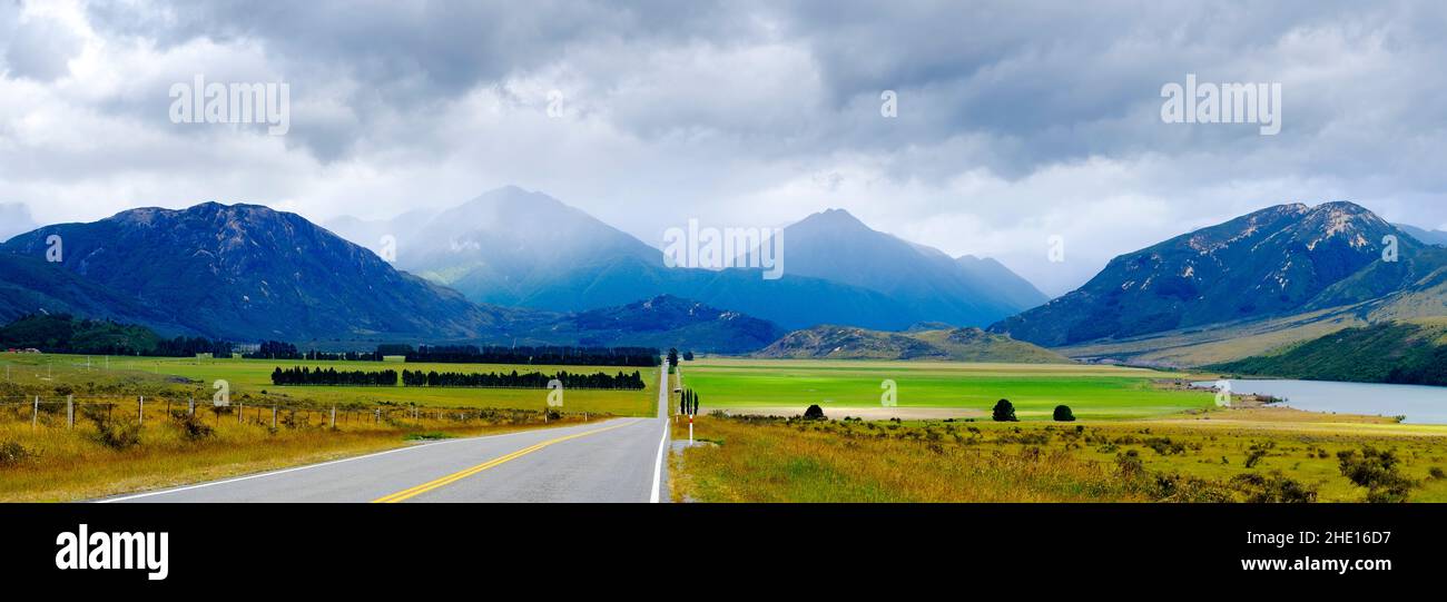 Strada diritta che conduce verso le montagne nebbre in Nuova Zelanda Foto Stock