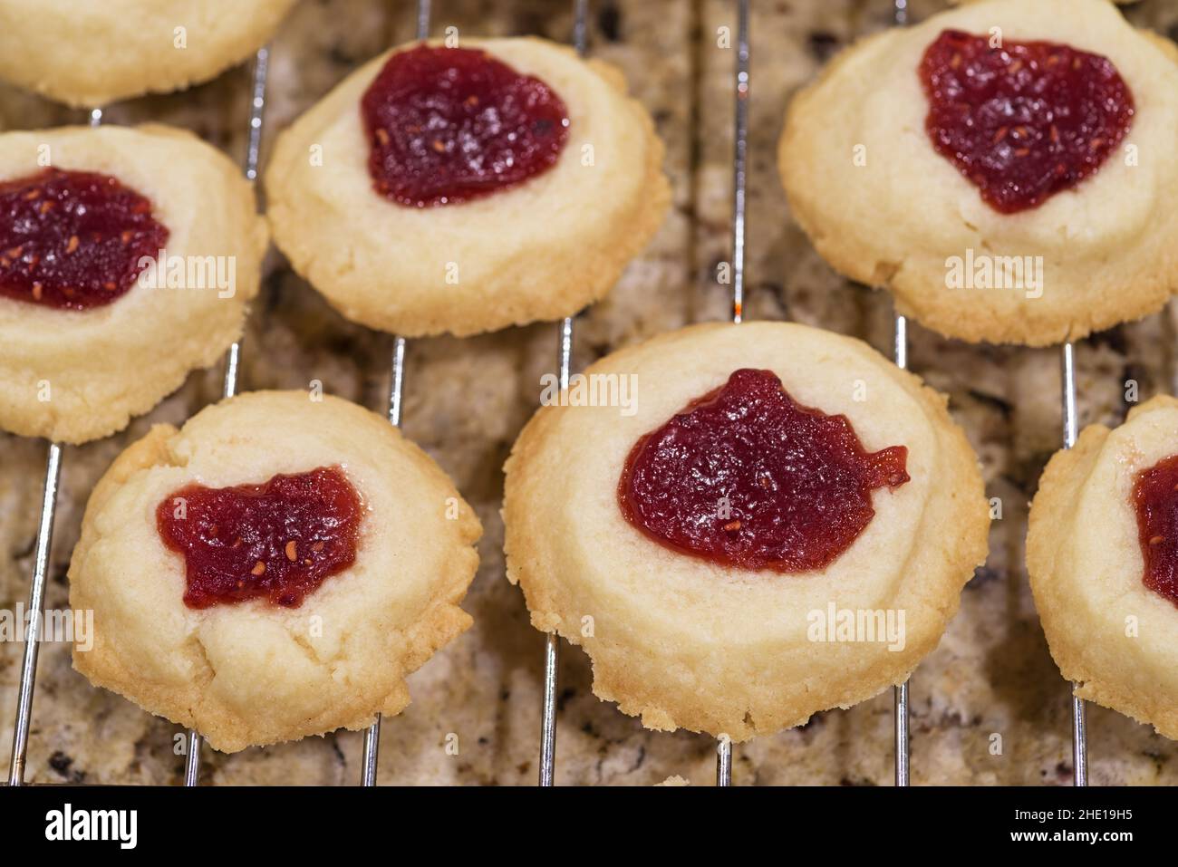biscotti fatti in casa con thumbprint di shortbread al lampone che si raffreddano su un rack Foto Stock