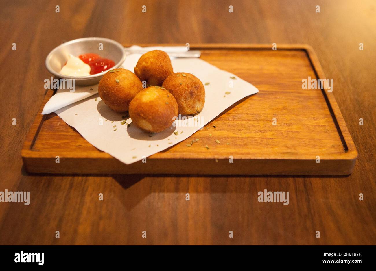 Bitterballen in un contenitore di legno con salsa di peperoncino e maionese. Vista dall'alto Foto Stock