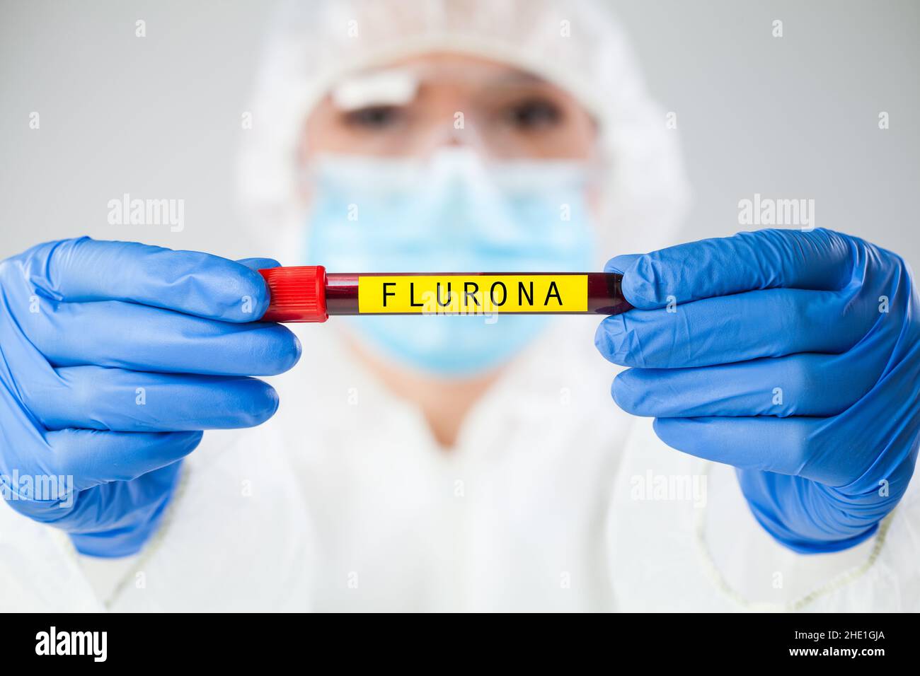 Medico medico operatore che detiene il portacampioni della provetta contenente il campione di sangue del paziente, SARS-COV-2 FLURONA Variant Concept, New Coronavirus flu Foto Stock