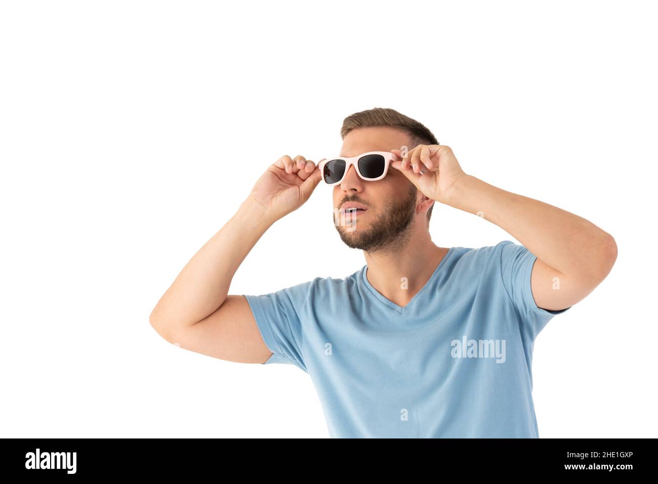 Uomo sorpreso che guarda in su con un occhiali da sole su uno sfondo bianco Foto Stock