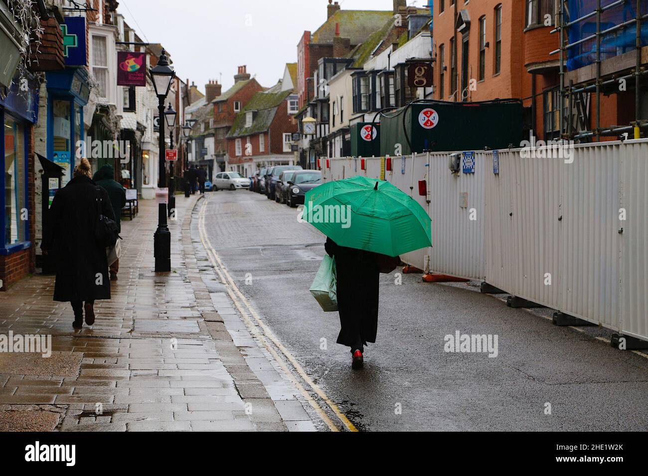 Segale, East Sussex, Regno Unito. 08 Jan 2022. Tempo UK: I visitatori dell'antica città di Rye camminano lungo la strada principale tenendo ombrelloni come più pesante pioggia è previsto più tardi. Photo Credit: Paul Lawrenson /Alamy Live News Foto Stock