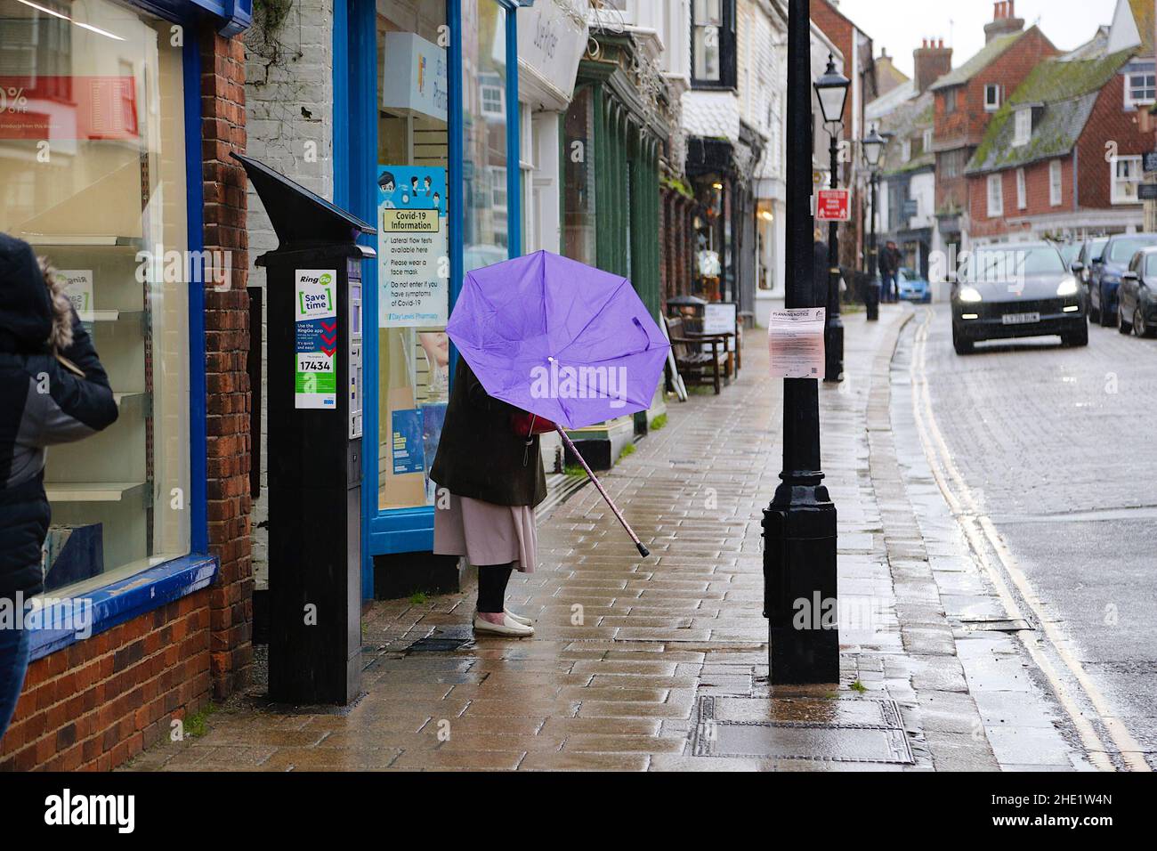 Segale, East Sussex, Regno Unito. 08 Jan 2022. Tempo UK: I visitatori dell'antica città di Rye camminano lungo la strada principale tenendo ombrelloni come più pesante pioggia è previsto più tardi. Photo Credit: Paul Lawrenson /Alamy Live News Foto Stock