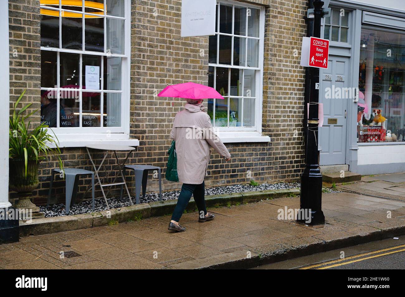 Segale, East Sussex, Regno Unito. 08 Jan 2022. Tempo UK: I visitatori dell'antica città di Rye camminano lungo la strada principale tenendo ombrelloni come più pesante pioggia è previsto più tardi. Photo Credit: Paul Lawrenson /Alamy Live News Foto Stock