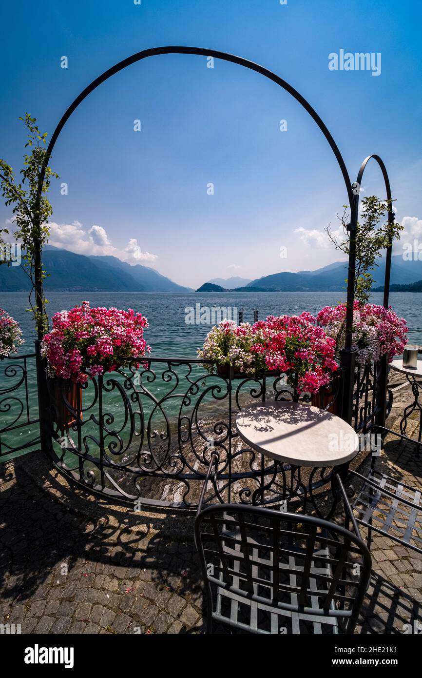 Tavoli e sedie di un ristorante ben disposti sul lago con fiori e vista sul  lago di Como Foto stock - Alamy