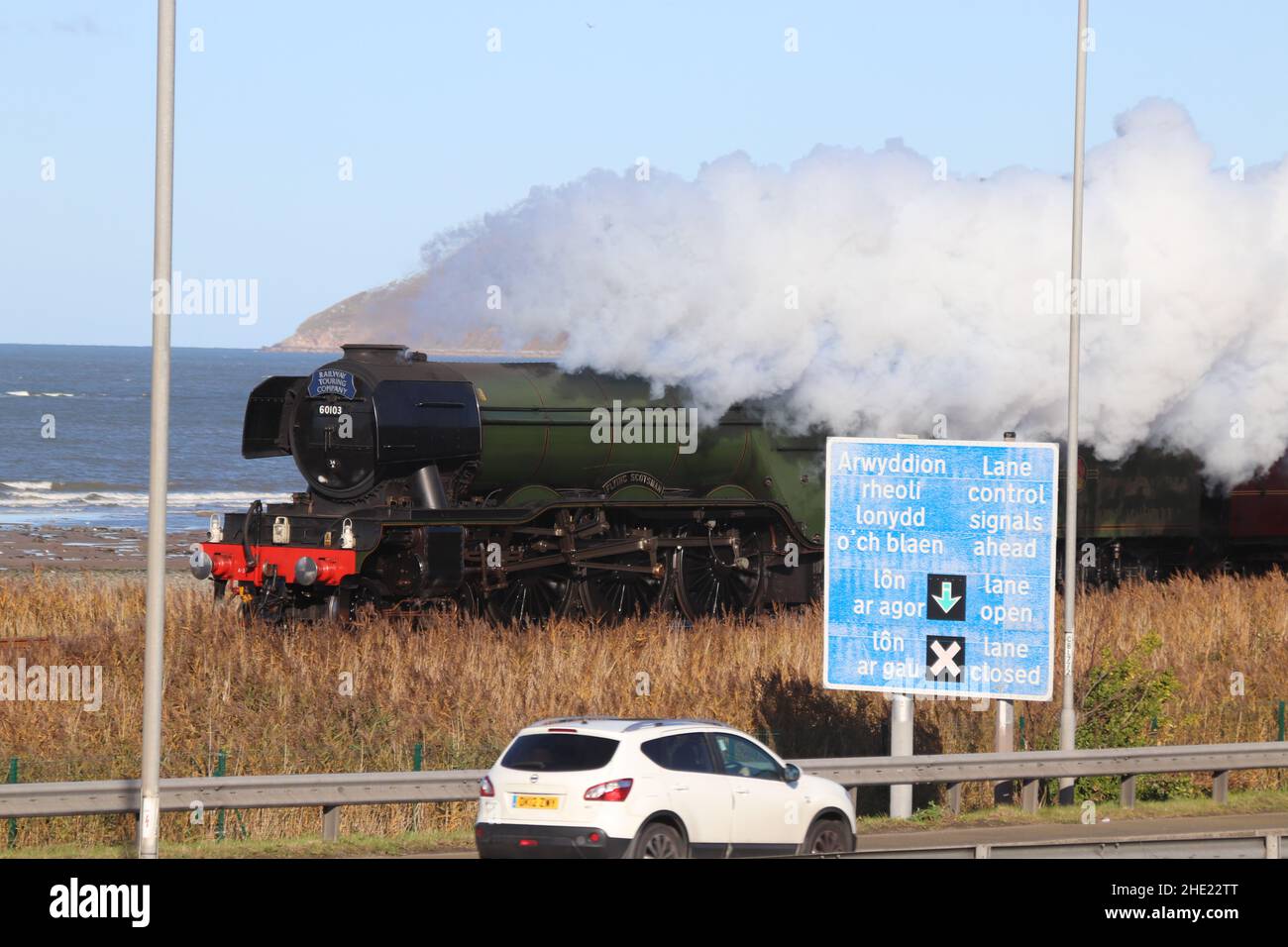 Il Flying Scotsman sulla linea costiera del Galles del Nord. Il treno a vapore ferma a Crewe, Llandudno Junction e Holyhead Wales Foto Stock