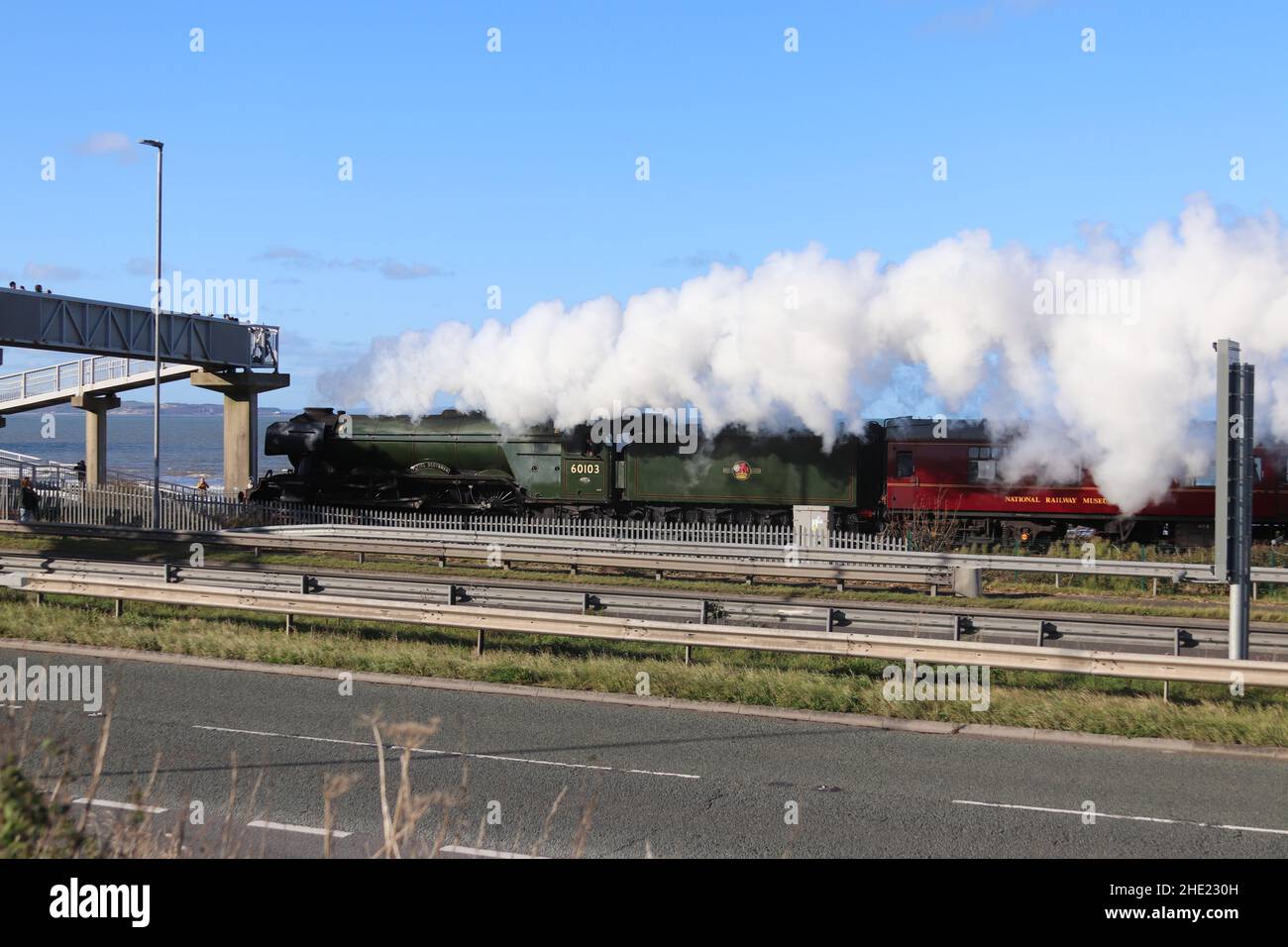 Il Flying Scotsman sulla linea costiera del Galles del Nord. Il treno a vapore ferma a Crewe, Llandudno Junction e Holyhead Wales Foto Stock