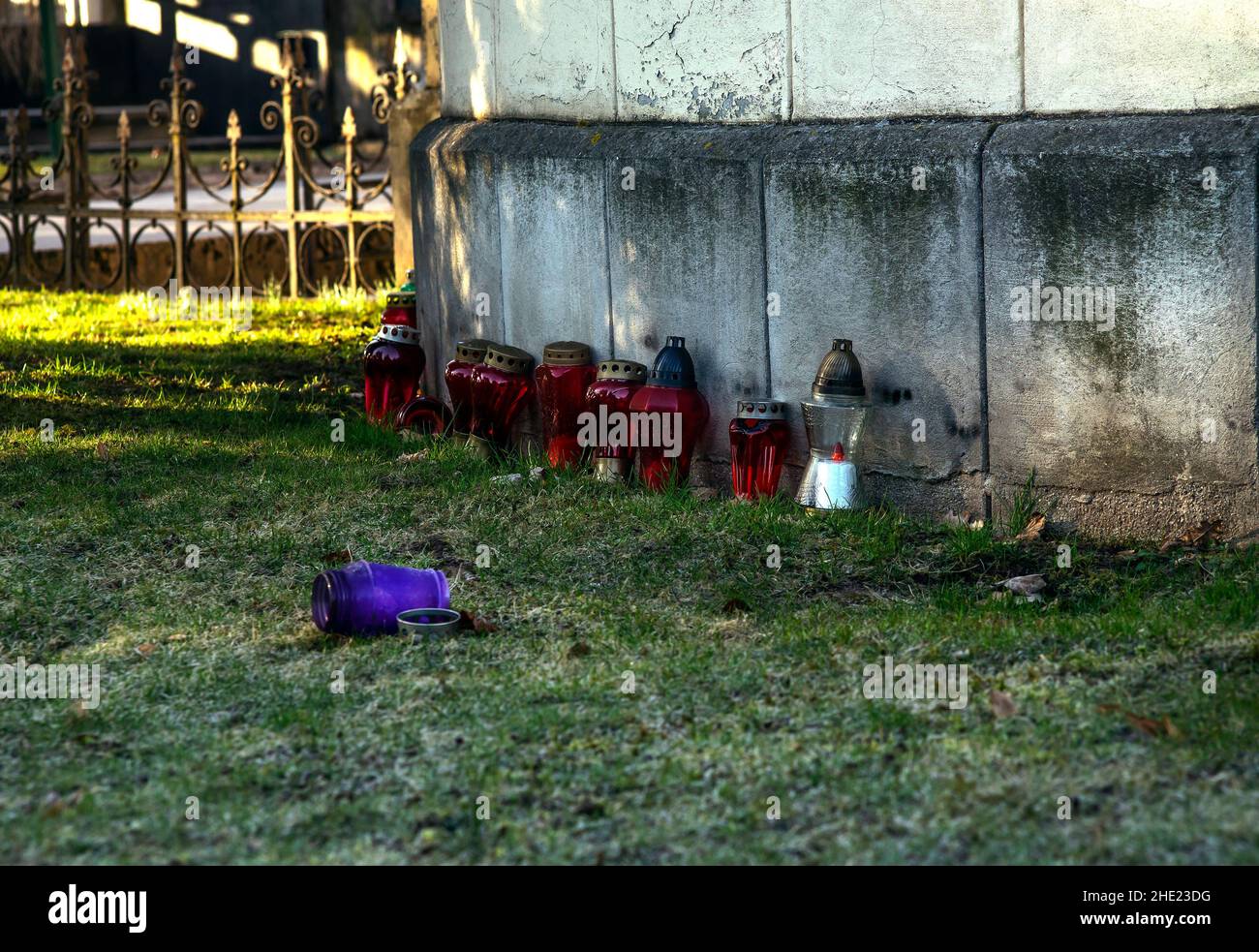 Candele bruciate poste contro un muro in un cimitero. Foto Stock