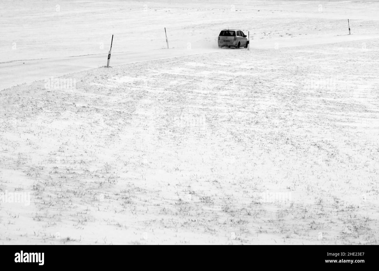 08 gennaio 2022, Baviera, Stötten: Un'automobile guida su una strada coperta di nevi. Foto: Karl-Josef Hildenbrand/dpa Foto Stock