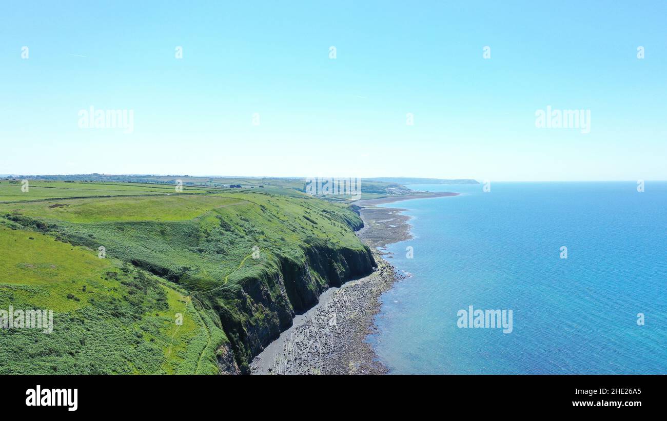 Immagine aerea della costa gallese e della scogliera a Llannon, Cerediaion. Cielo blu e mare, spiaggia di ciottoli, sentiero costiero. Foto Stock