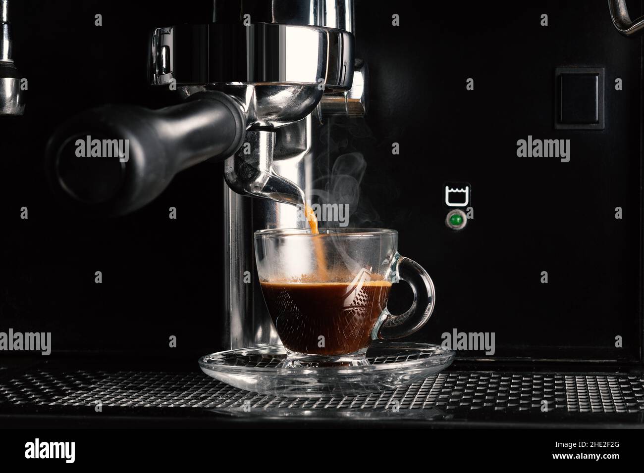 Vista ravvicinata della moderna macchina da caffè espresso che prepara il caffè in una tazza. Foto Stock