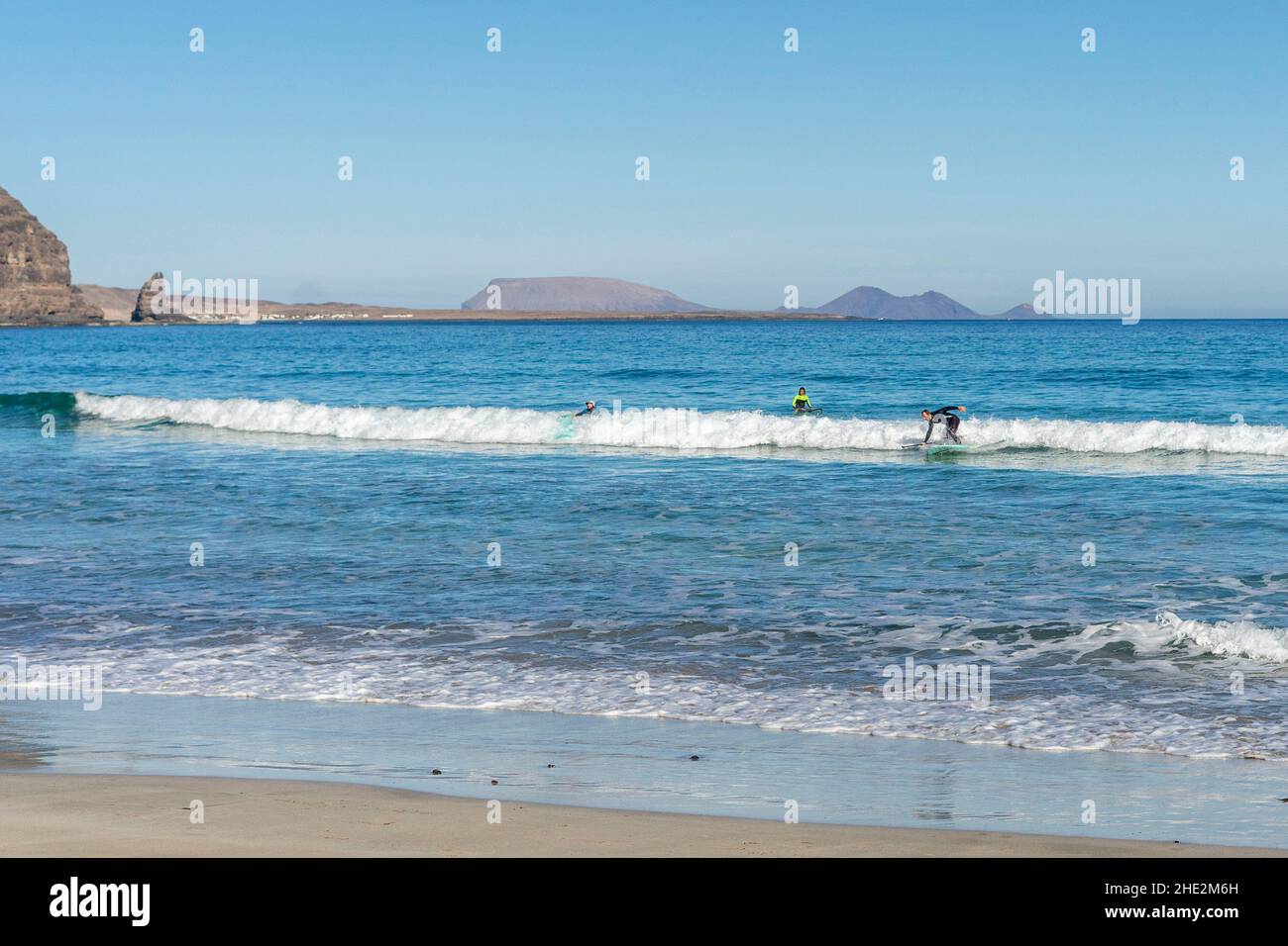 Impara a stare in piedi sulle onde dell'oceano in una giornata soleggiata e limpida a Canary Island Lanzarote Foto Stock