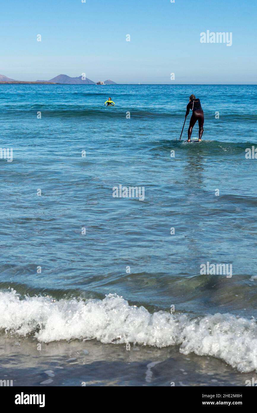 Impara a stare in piedi sulle onde dell'oceano in una giornata soleggiata e limpida a Canary Island Lanzarote Foto Stock