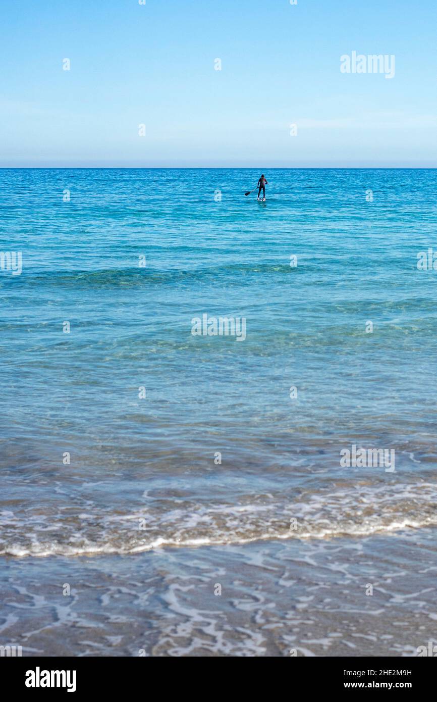 Impara a stare in piedi sulle onde dell'oceano in una giornata soleggiata e limpida a Canary Island Lanzarote Foto Stock