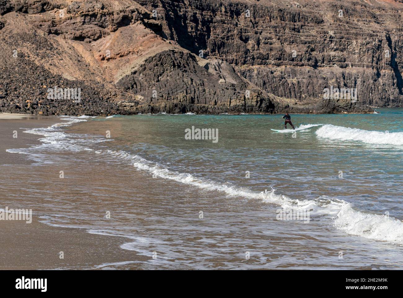 Impara a stare in piedi sulle onde dell'oceano in una giornata soleggiata e limpida a Canary Island Lanzarote Foto Stock