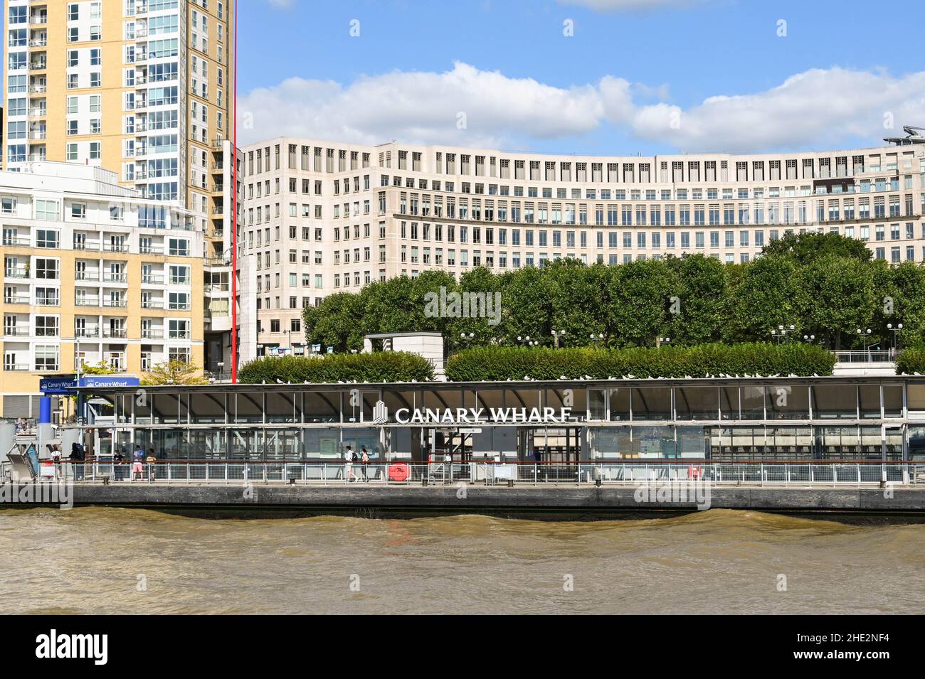 Londra, Inghilterra - Giugno 2021: Persone in attesa di un traghetto passeggeri sul molo di Canary Wharf nel centro di Londra. Foto Stock