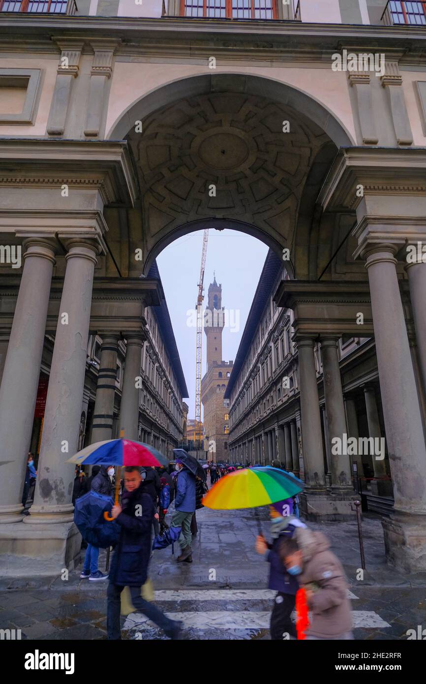 Firenze, Italia: Costruzione del Museo degli Uffizi e delle persone che si avvicinano con gli ombrelloni colorati Foto Stock