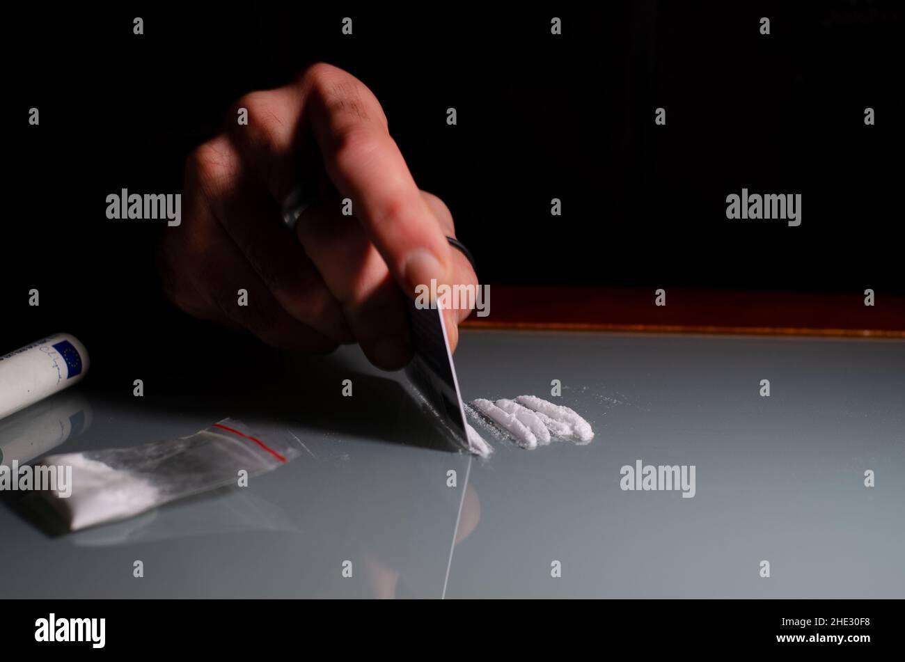 L'uomo divide la cocaina in strisce e poi russava. Concetto di narcotici. Foto Stock