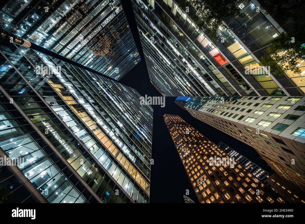 Business e finanza Concept, guardando in alto edificio di architettura di uffici di notte nel quartiere finanziario di una moderna metropoli. Foto Stock