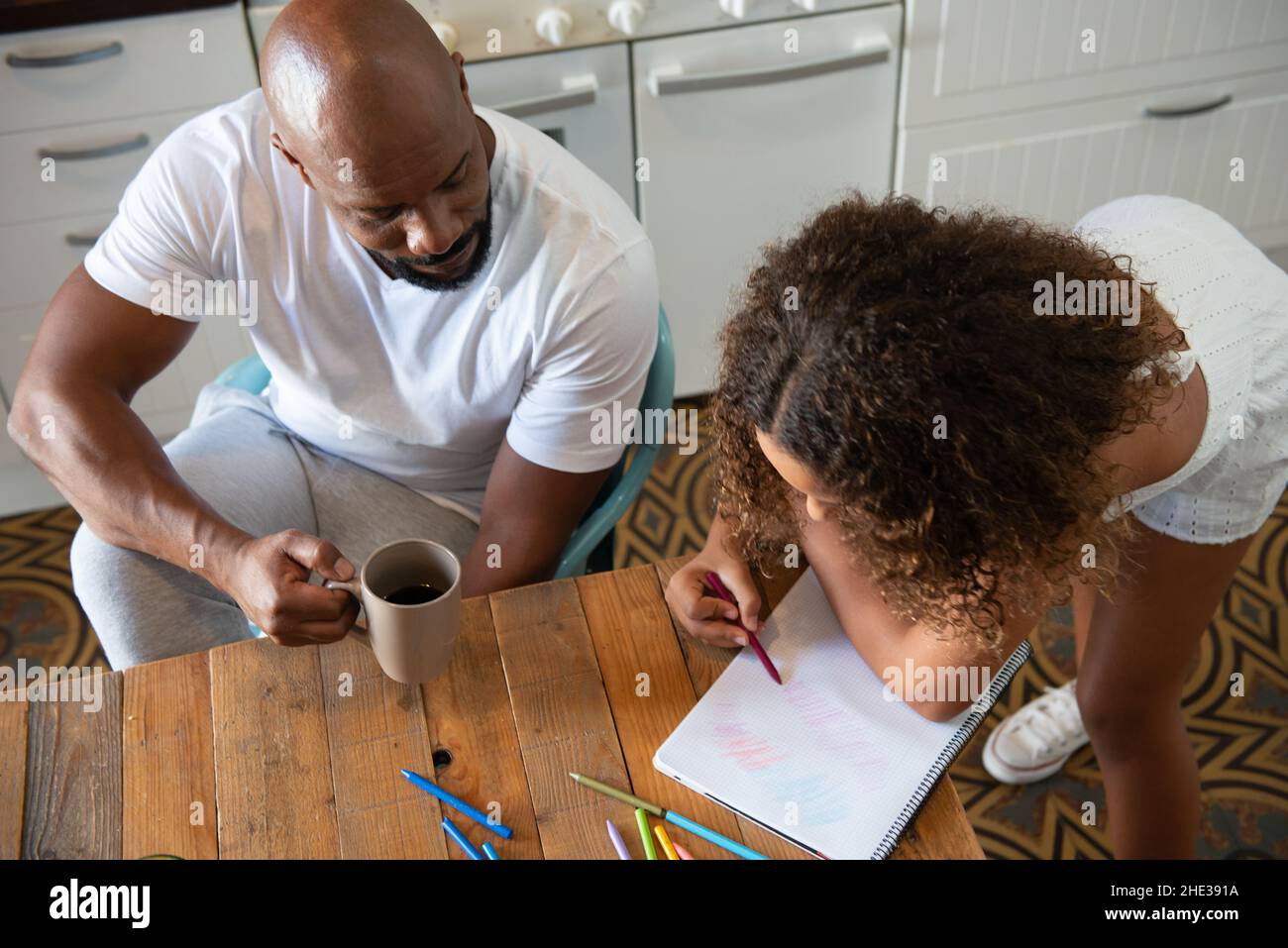 Famiglia multirazziale europea e afroamericana nella cucina della loro casa di condividere momenti Foto Stock