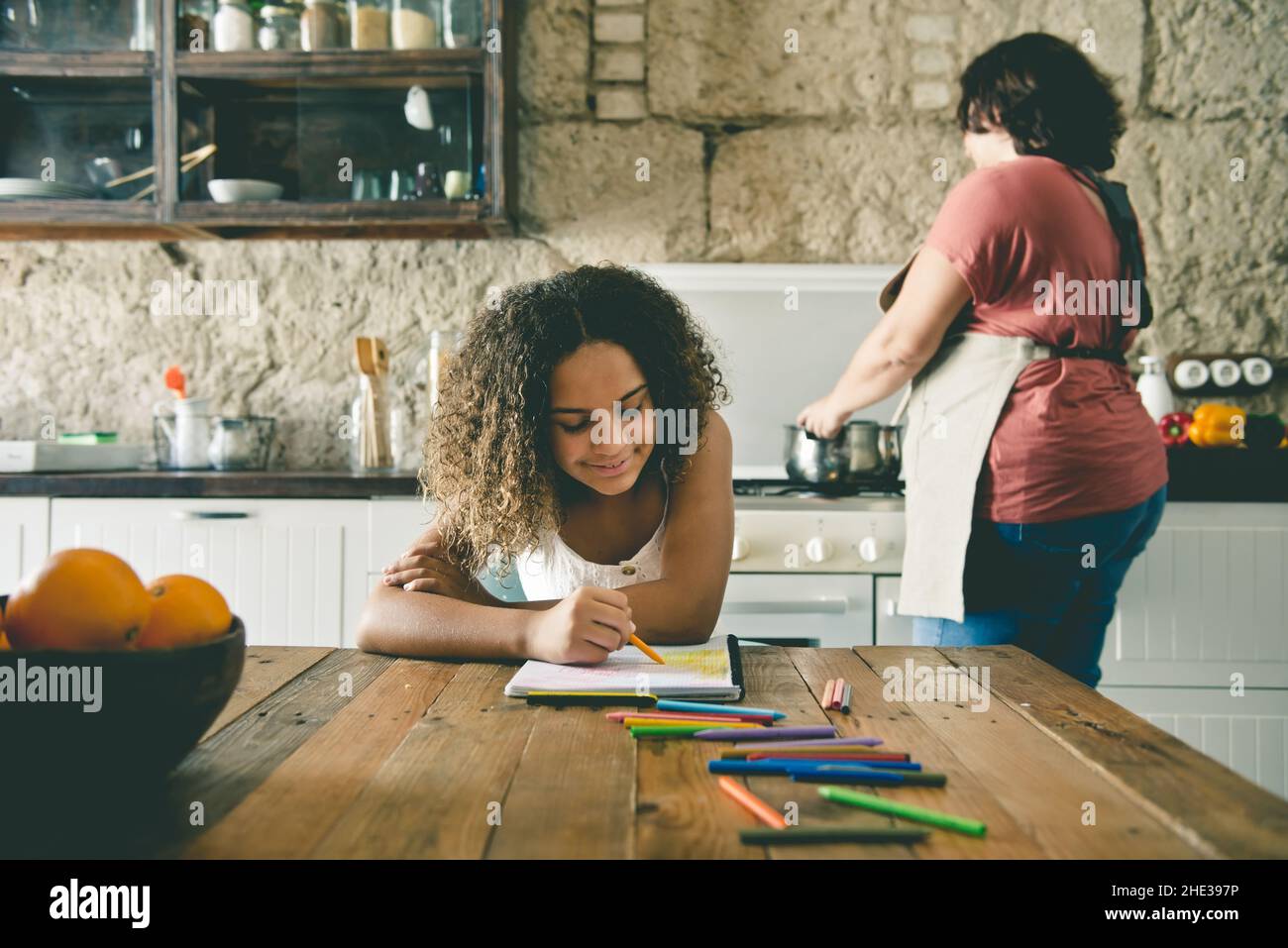 Famiglia multirazziale europea e afroamericana nella cucina della loro casa di condividere momenti Foto Stock