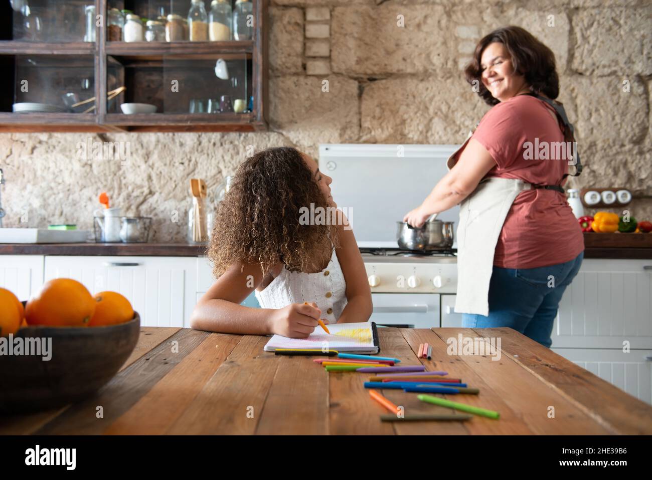 Famiglia multirazziale europea e afroamericana nella cucina della loro casa di condividere momenti Foto Stock