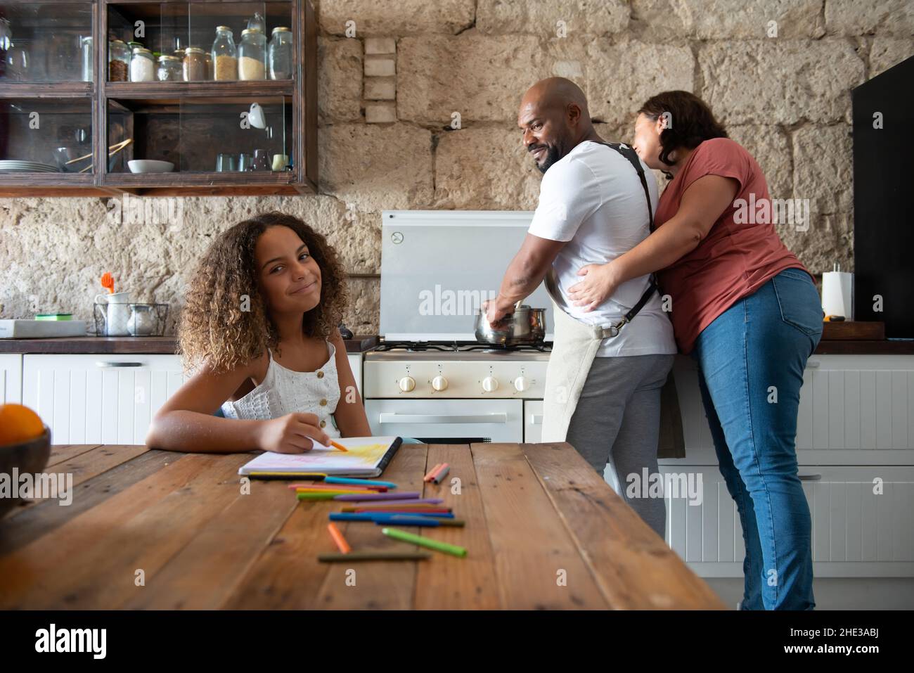 Famiglia multirazziale europea e afroamericana nella cucina della loro casa di condividere momenti Foto Stock