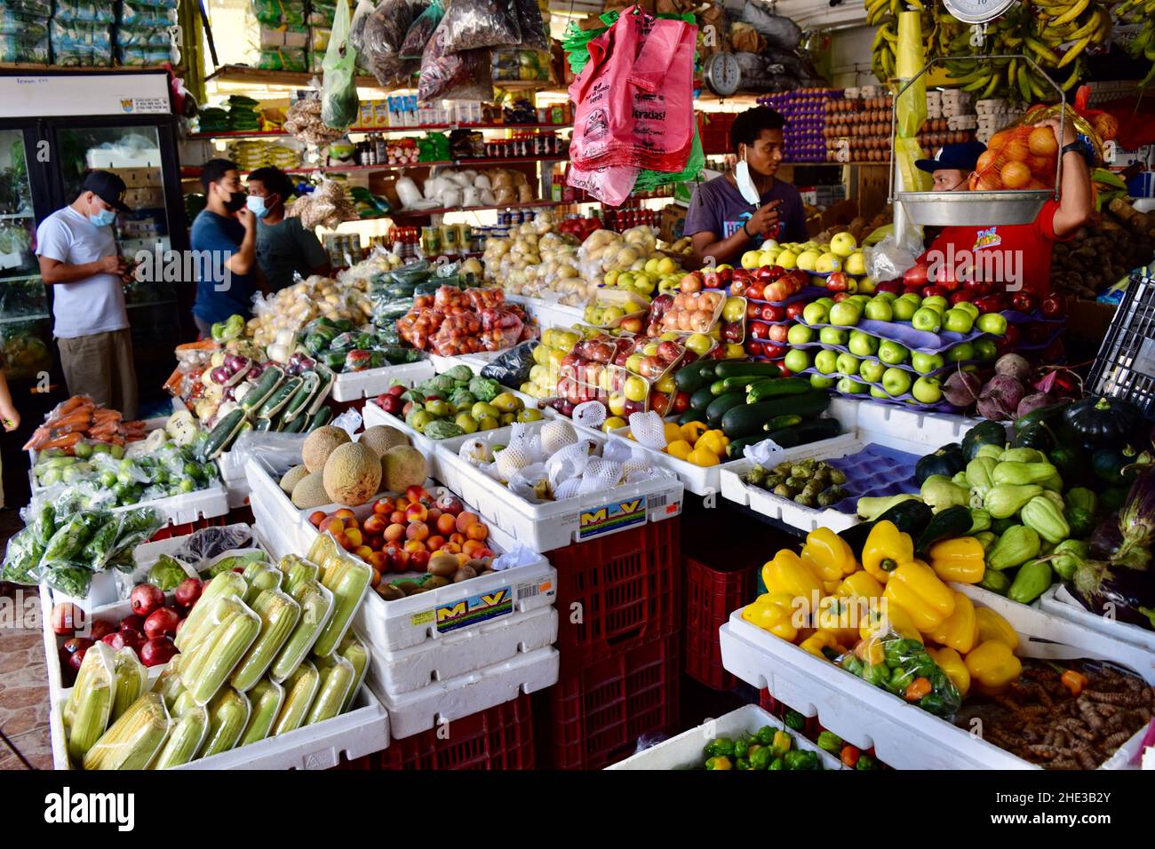 Venditori e clienti tra alcuni dei prodotti offerti al Belize City Market. Foto Stock